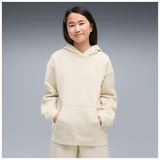 Sudadera Puma junior crudo con capucha y bolsillo canguro, vista frontal sobre modelo