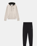 Chándal Champion hombre beige y negro, sudadera con capucha y pantalón vistos por separado