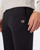 Detalle del pantalón negro Champion con logotipo en el muslo